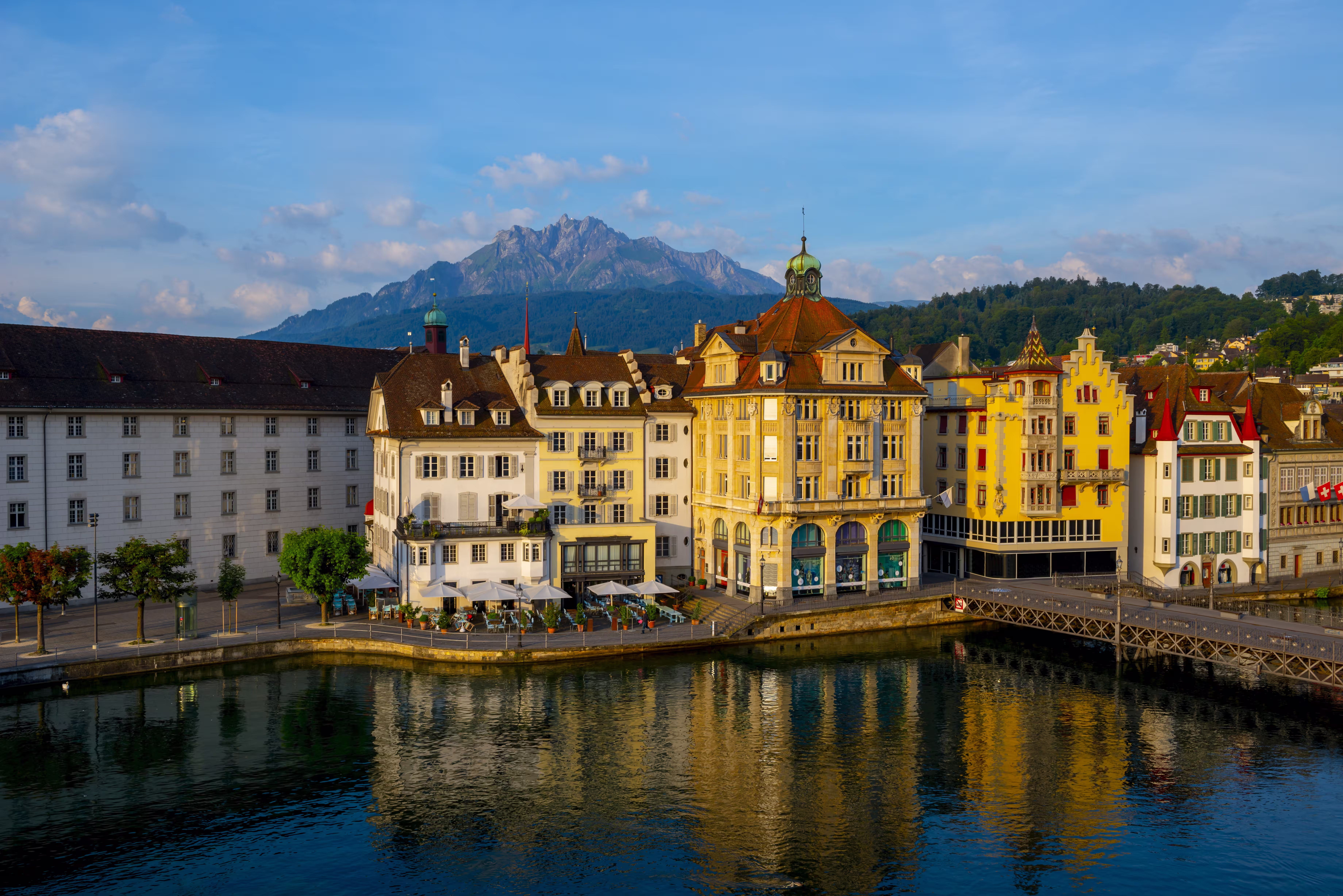 colorful buildings near a river surrounded by mountains